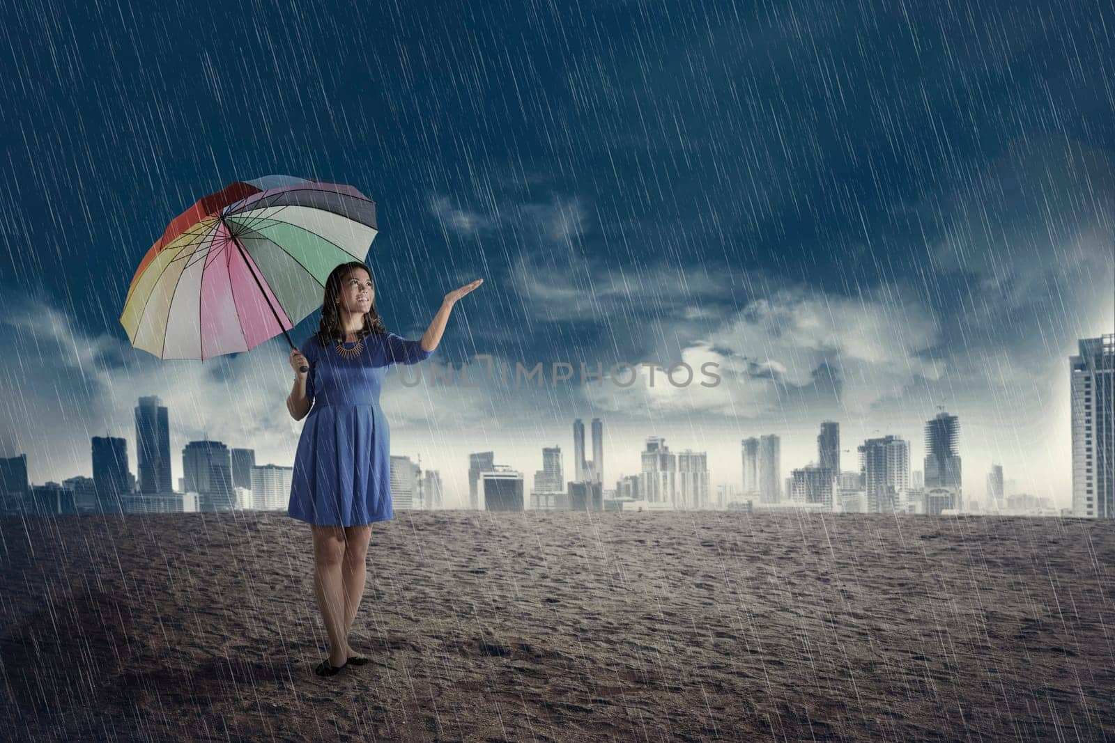 Happy asian woman with umbrella when rain over dark sky background
