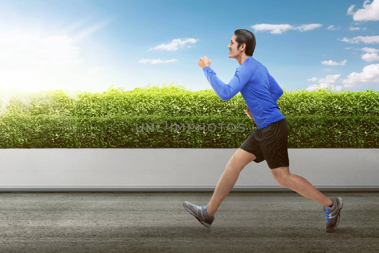 Attractive asian man running on the morning at park