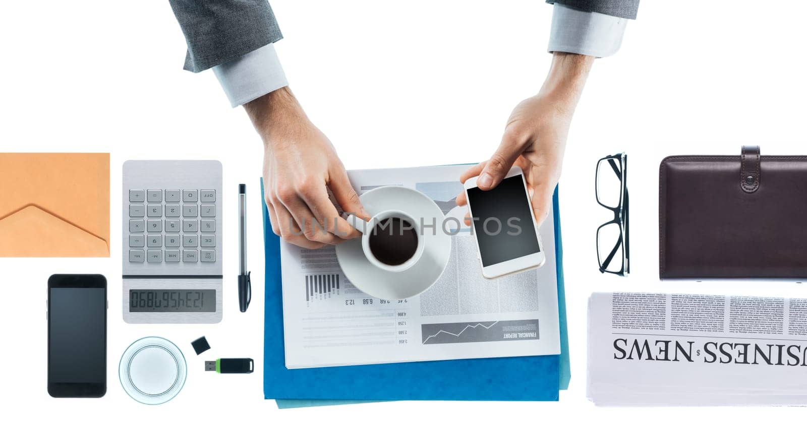 Businessman having a coffee break holding an espresso and a smartphone, hands close up, top view