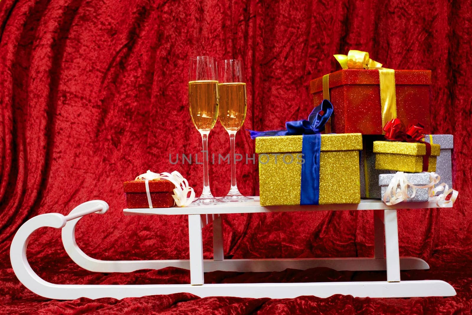 Two glass with champagne with chocolates and present box