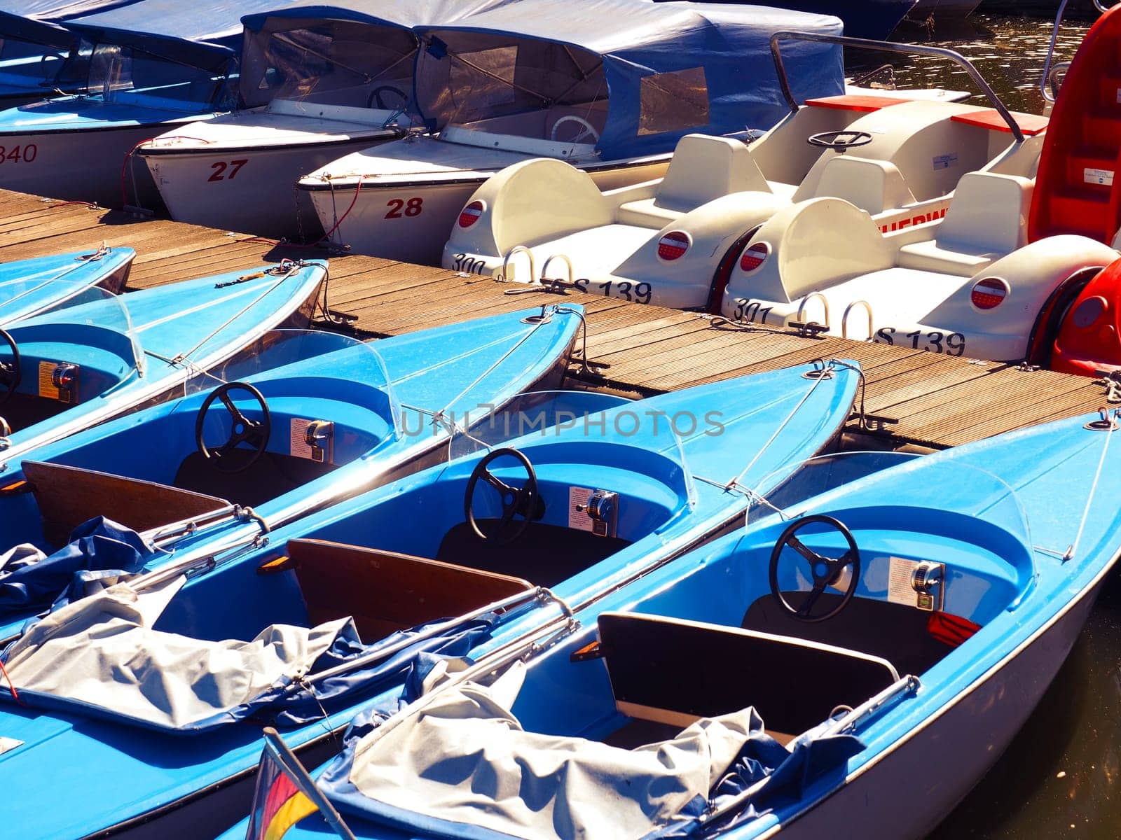 Colorful electric boats on a boat bridge of a small lake