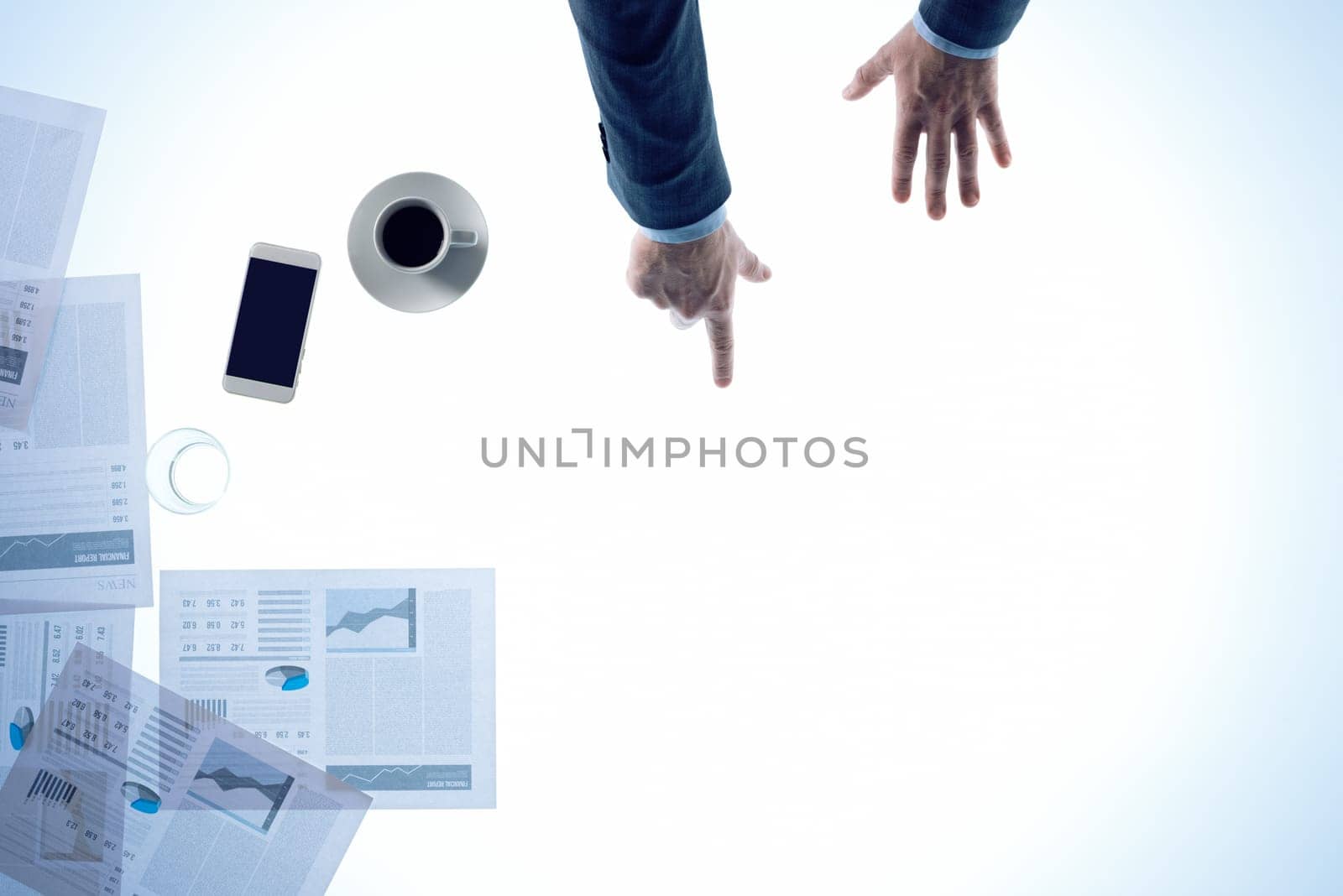 Businessman pointing to a white desktop with financial reports and blank copy space, top view