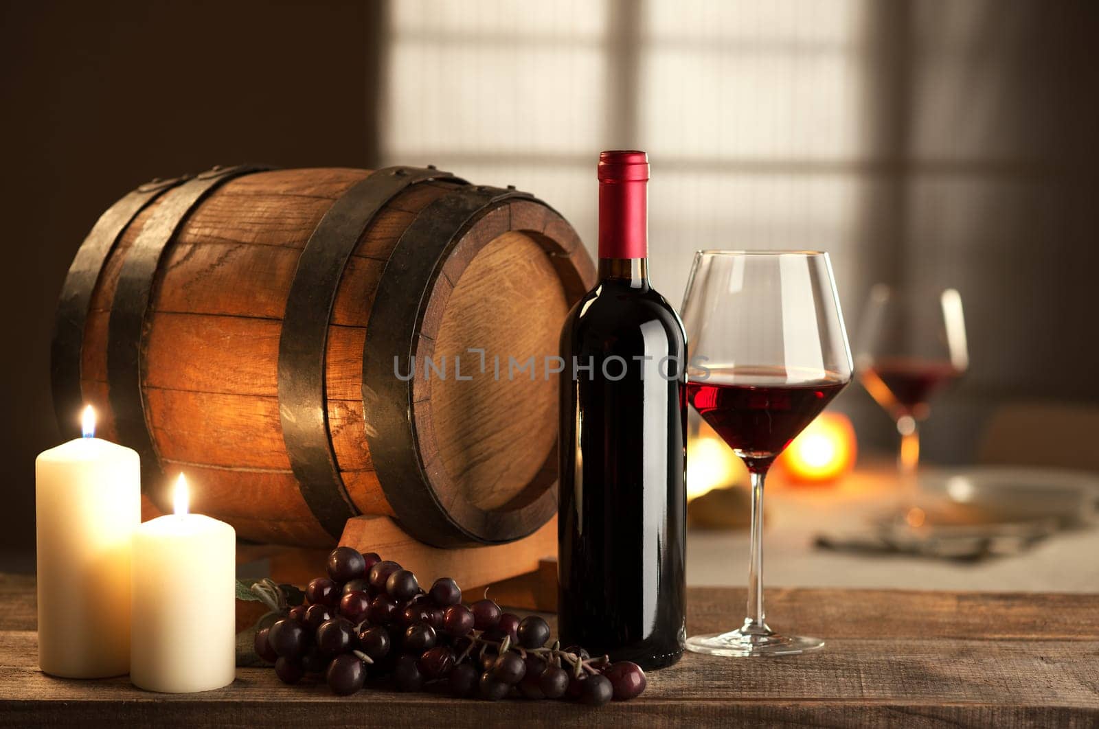Bottle, glass, grape and barrel still life with restaurant on background.