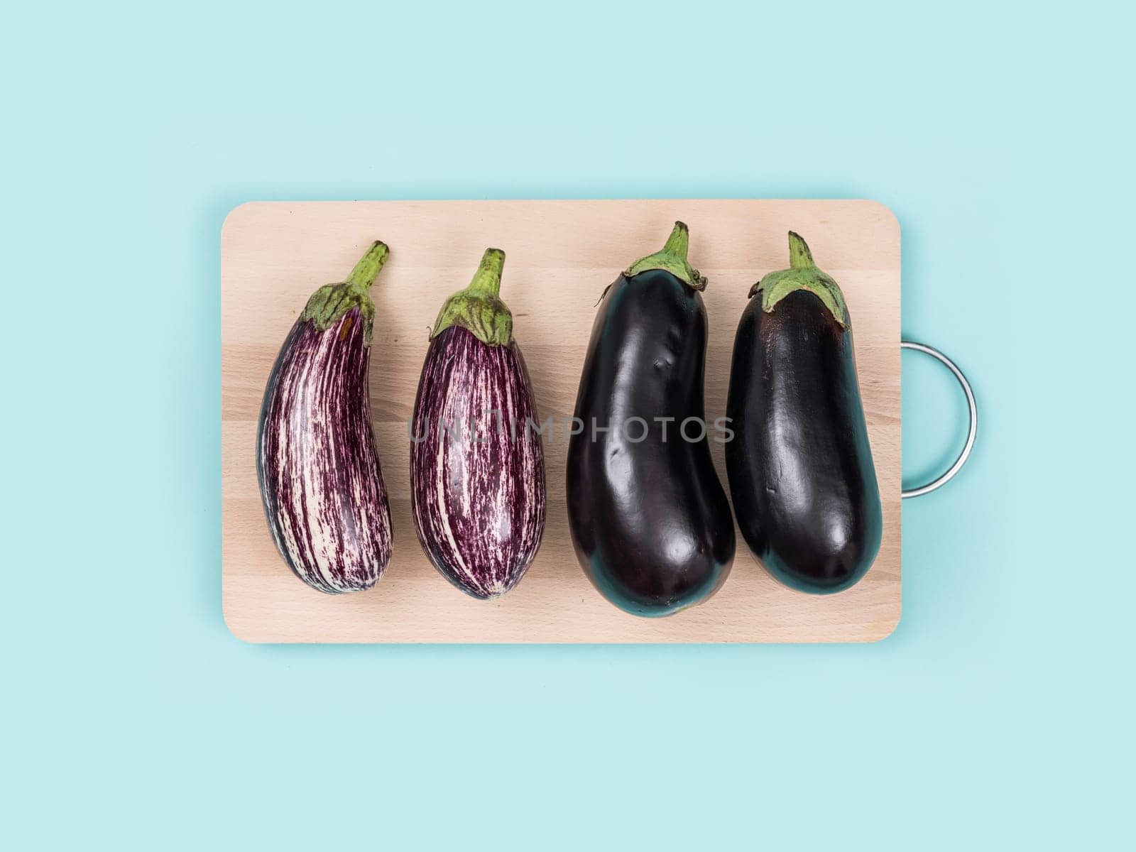 Fresh eggplants on a wooden chopping board, food preparation and healthy eating concept