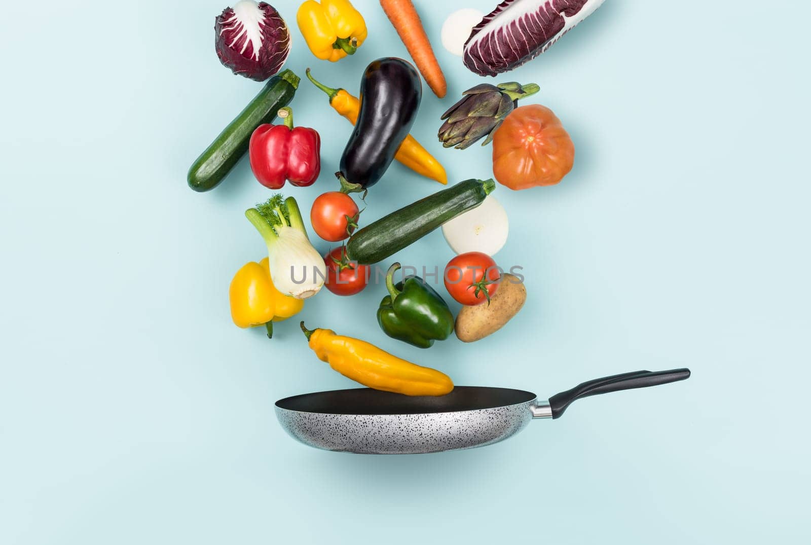Fresh healthy vegetables falling in a pan, healthy food and cooking concept