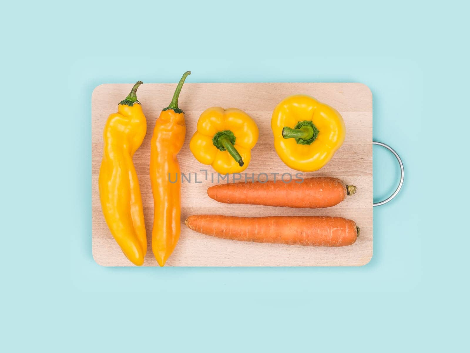 Fresh carrots and peppers on a wooden chopping board, cooking and healthy eating concept
