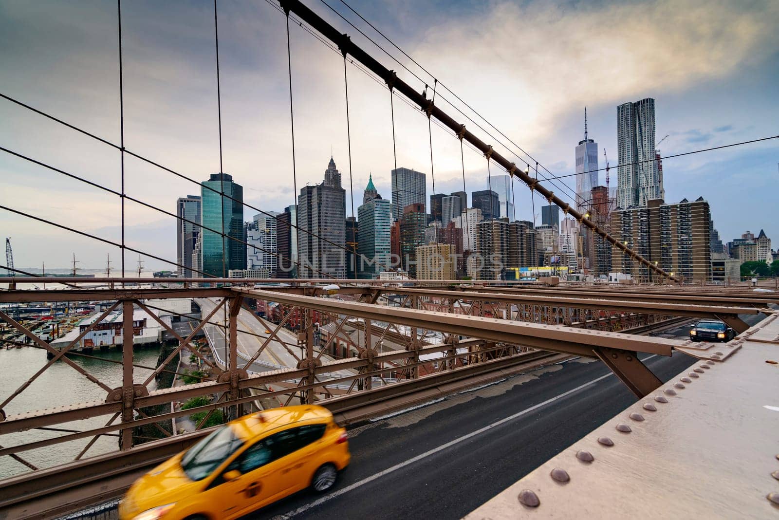 Brooklyn Bridge, New York, United States - June 08, 2015: Panoramic views from brooklyn bridge, skyscrapers and passing cars, the Manhattan skyline.