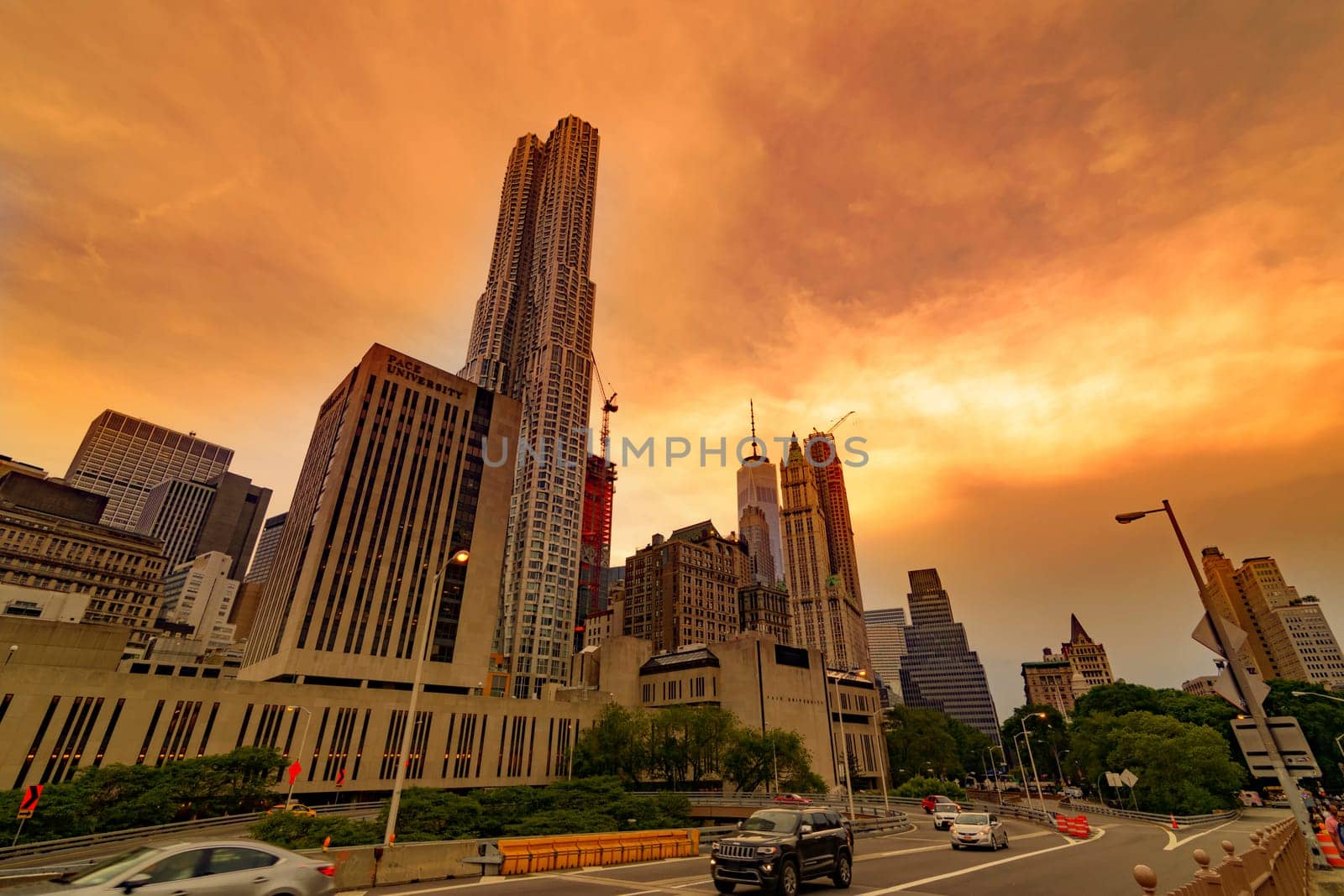 Brooklyn Bridge, New York, United States - June 08, 2015: People walk and while other tourists observe, from the bridge, the Manhattan skyline.