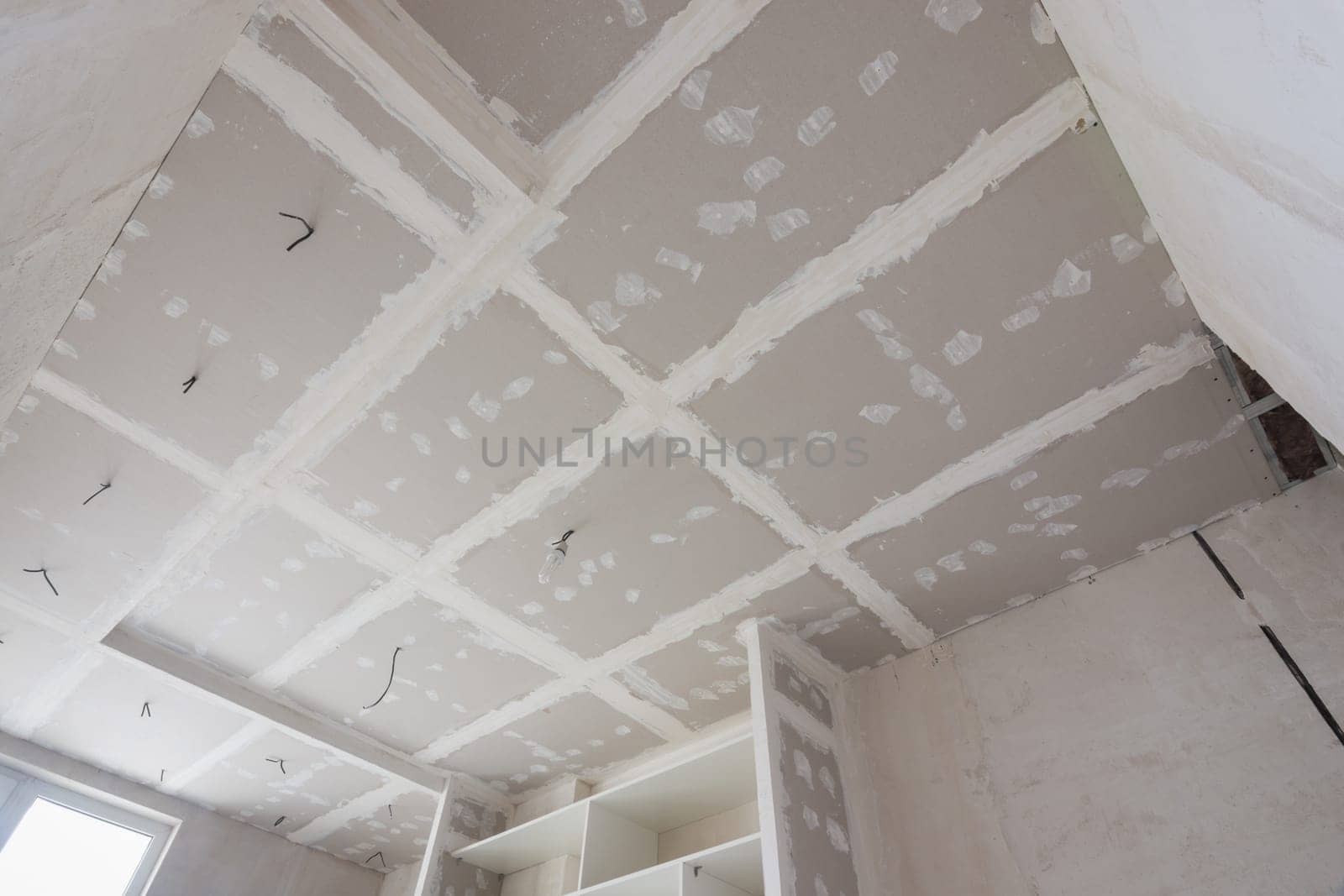The ceiling is covered with plasterboard sheets during the repair process