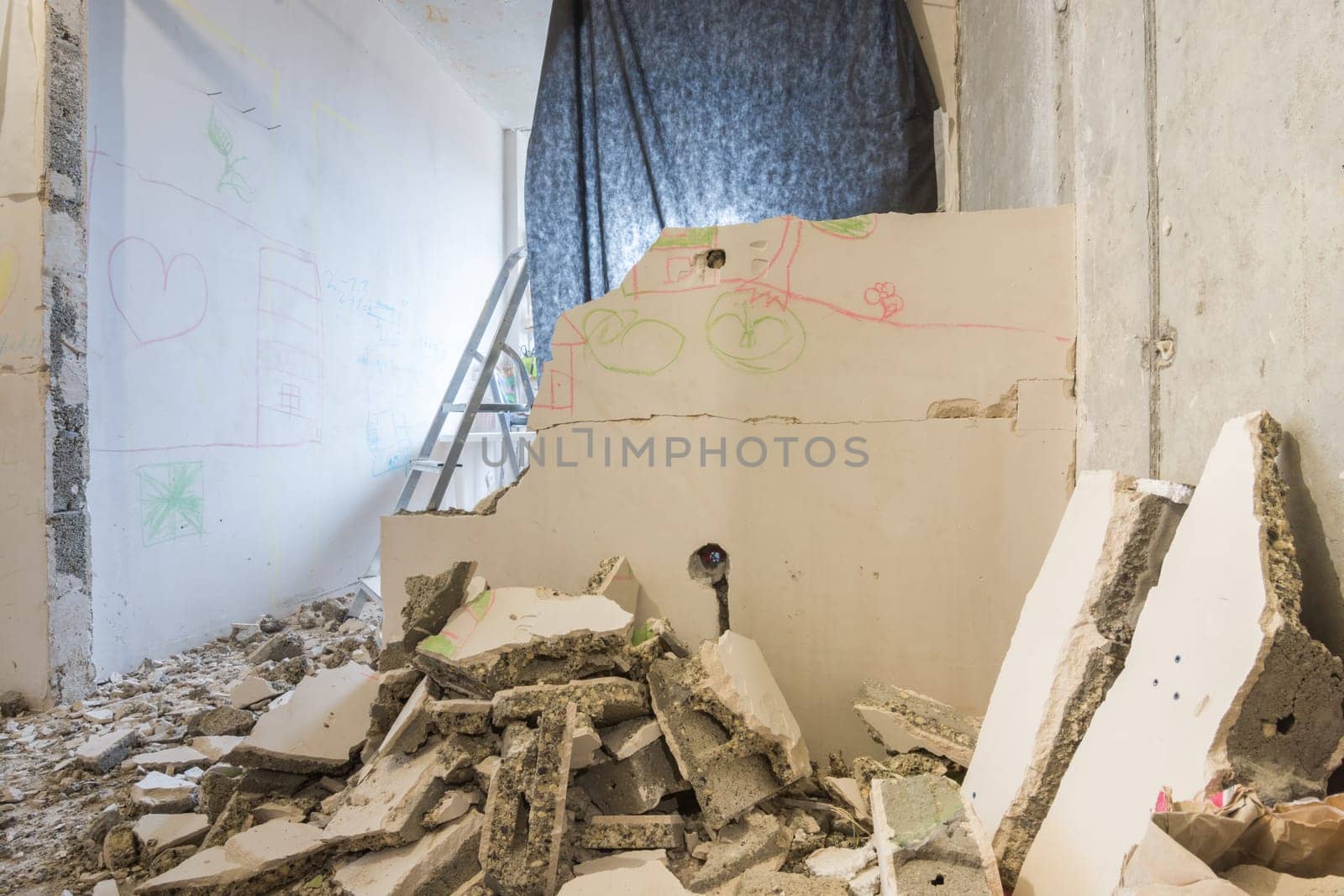 Dismantling of partitions in the apartment, around a heap of broken parts of the wall