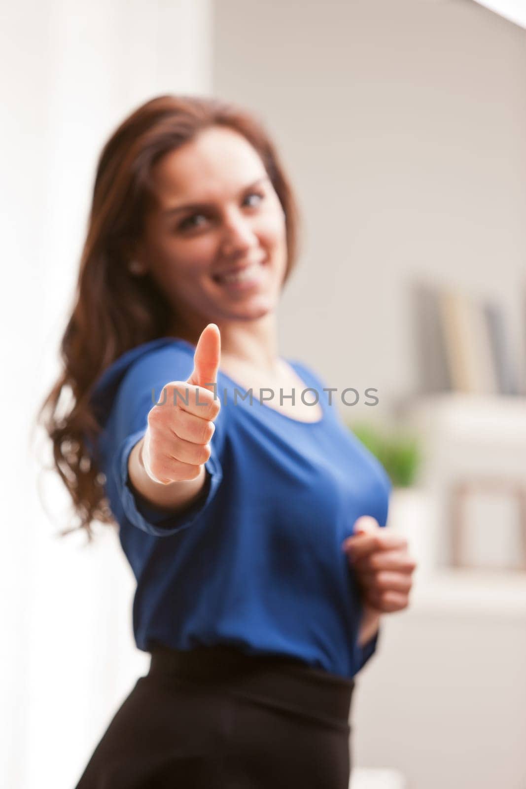 girl raising thumbs up in her living room happily