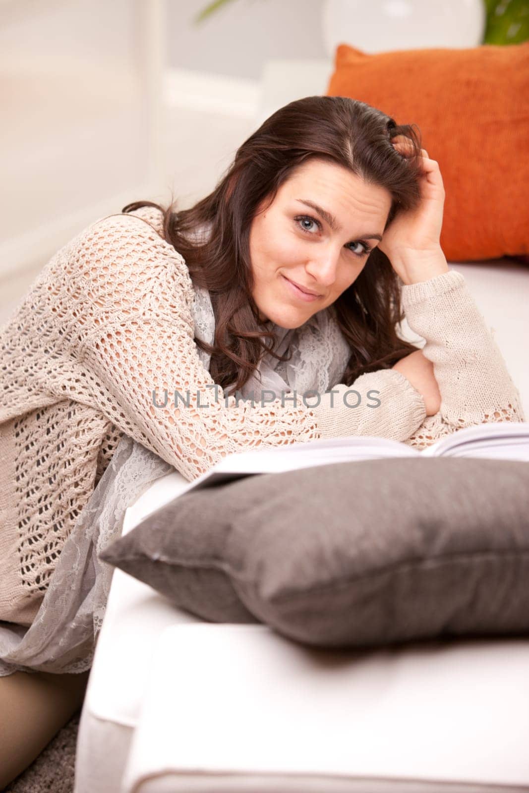 girl reading a book on her living room on a sofa