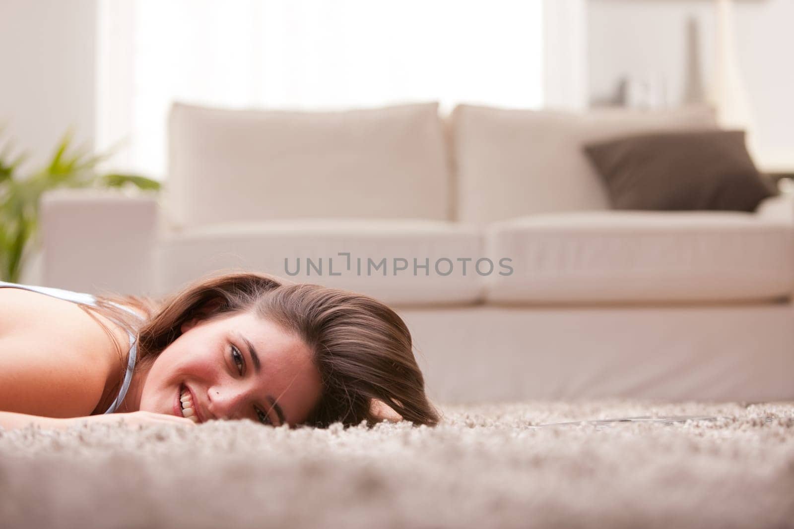 happy girl on the carpet in her living room laughing or smiling