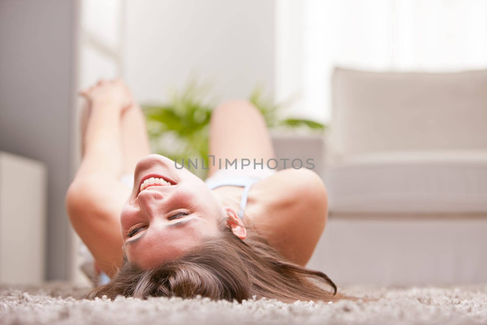 girl rolling on the floor laughing because of his irrepressible joy and happiness