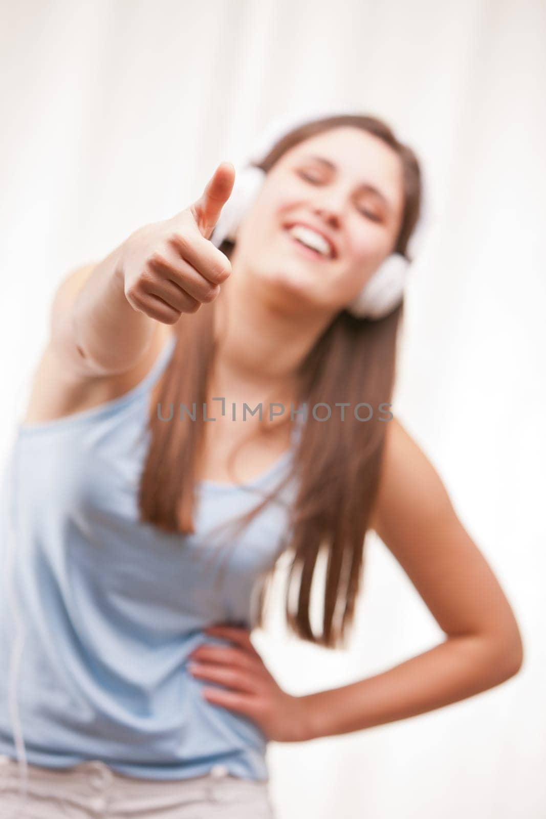 girl with thumbs up listening to music in her white headphones