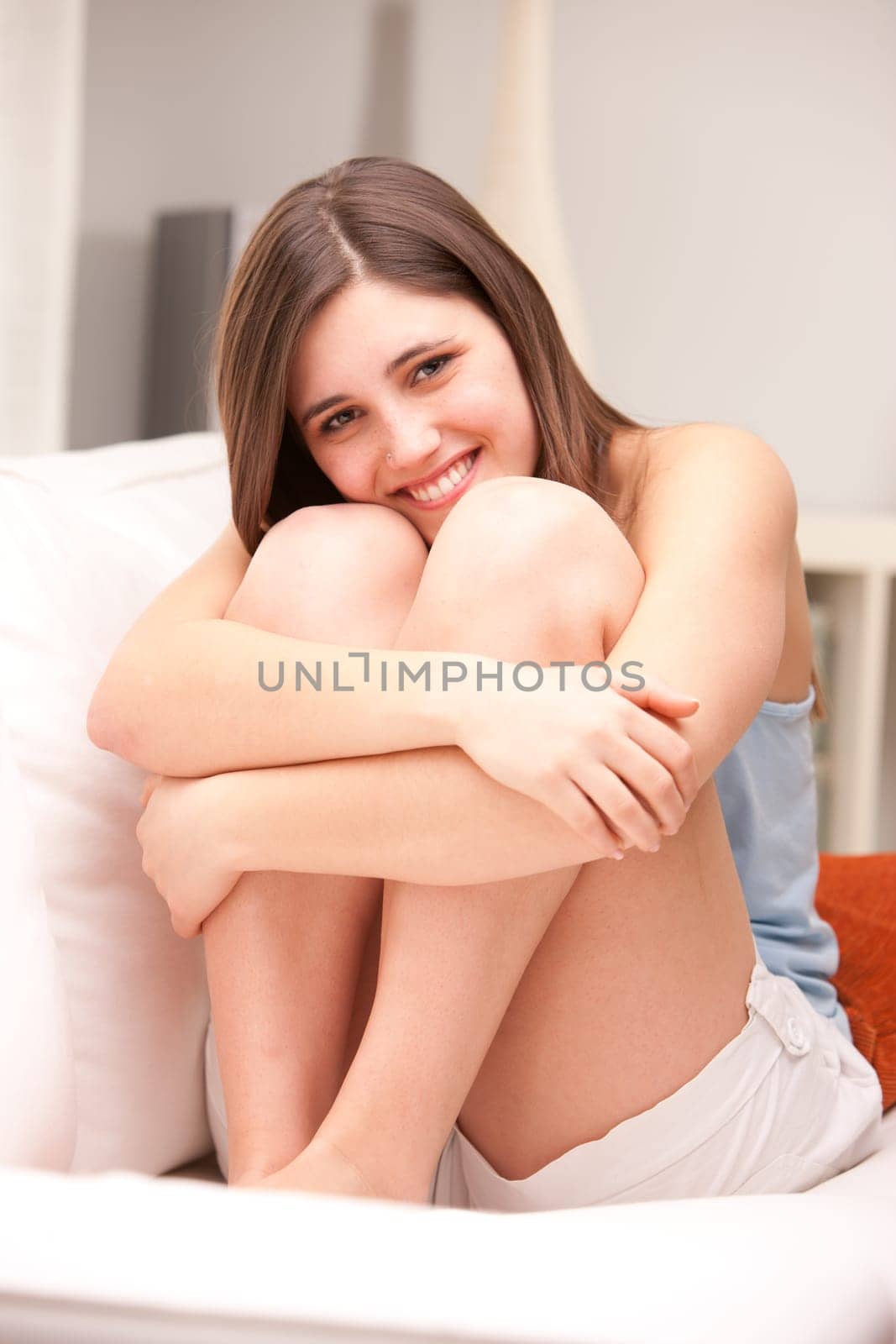 beautiful girl smiling shy on her sofa in her shiny living room