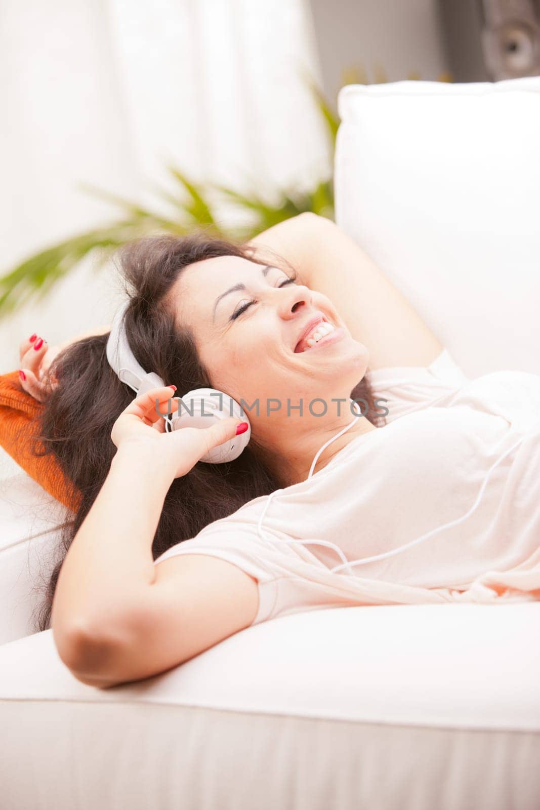 girl listening to music in her house dancing and singing happily in her living room