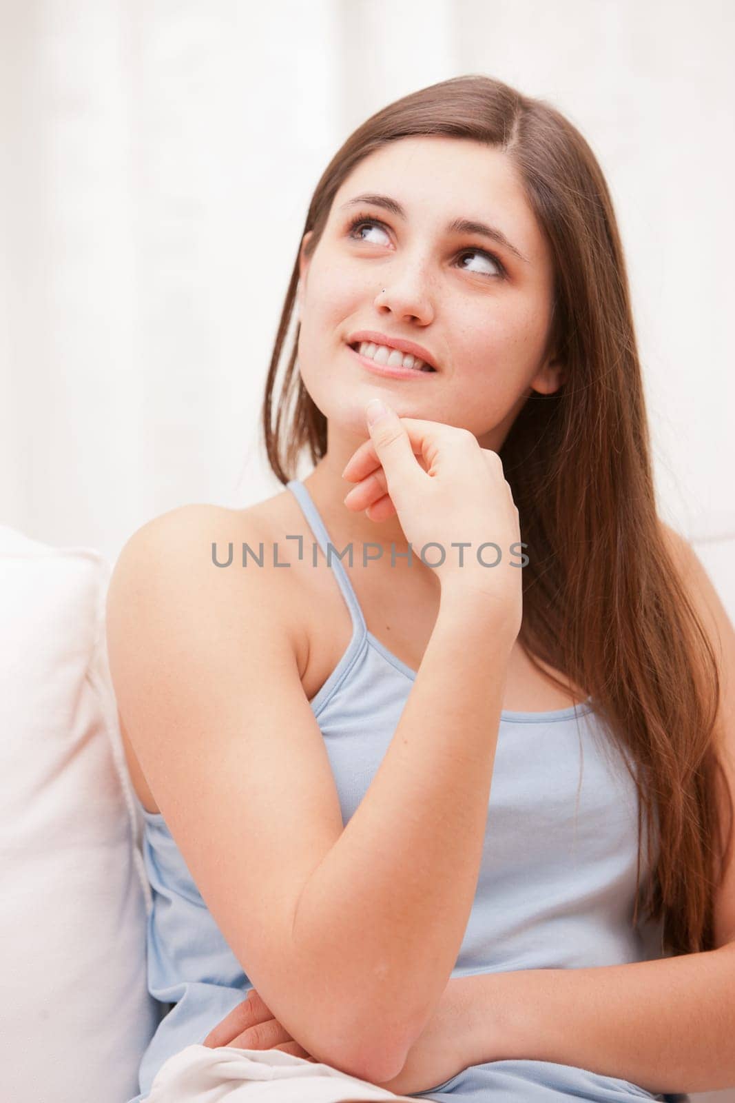beautiful girl smiling shy on her sofa in her shiny living room