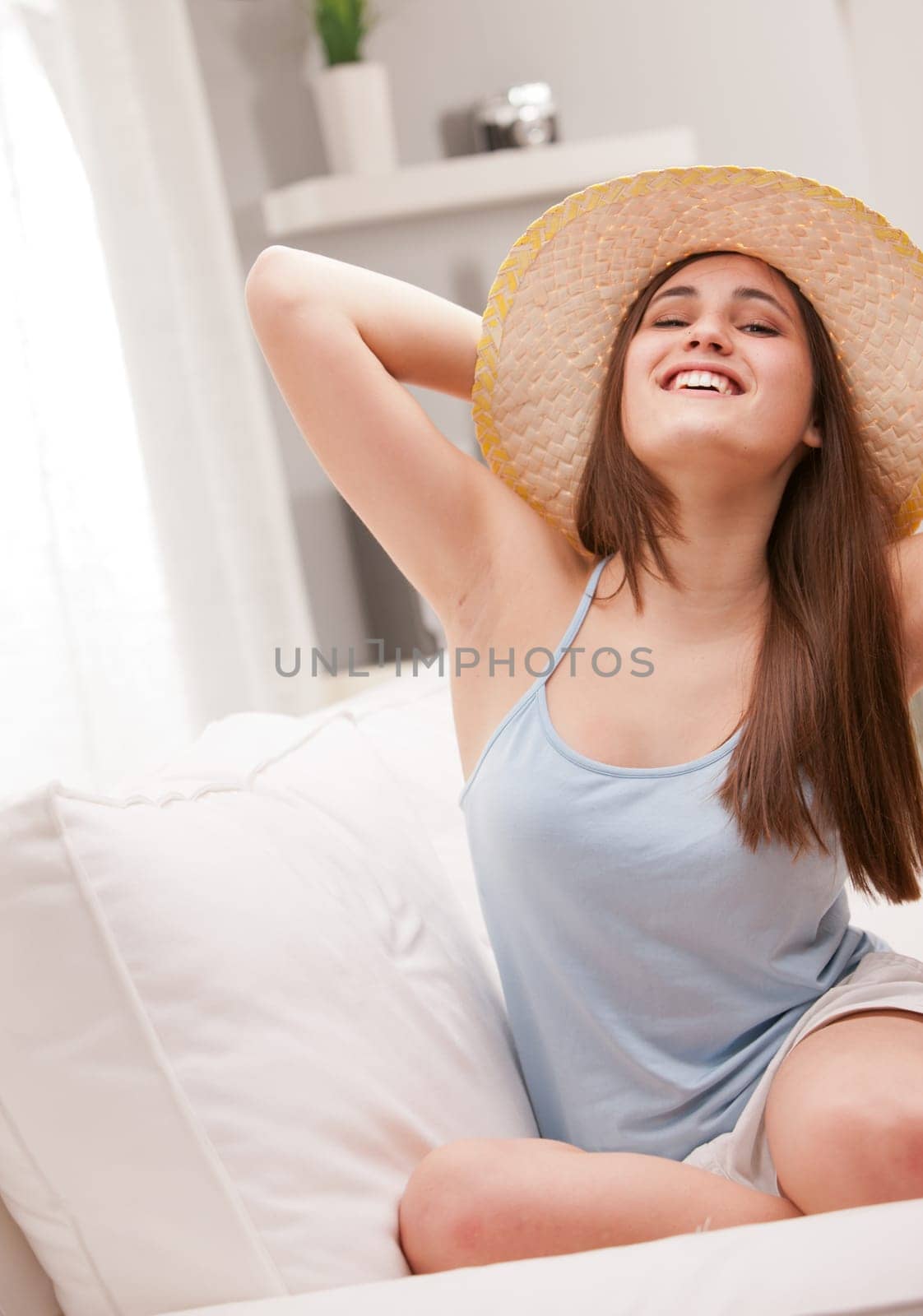 a girl pretending to be a rich and famous lady on the beach with a typical straw hat