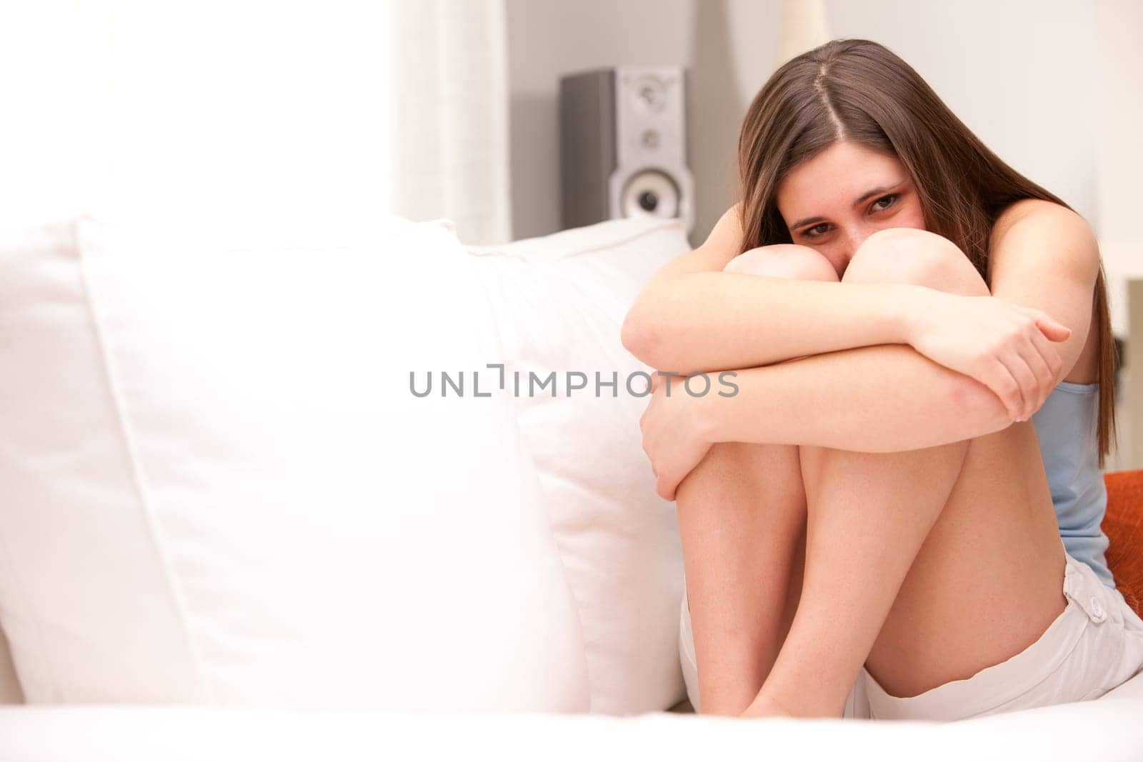 beautiful girl smiling shy on her sofa in her shiny living room