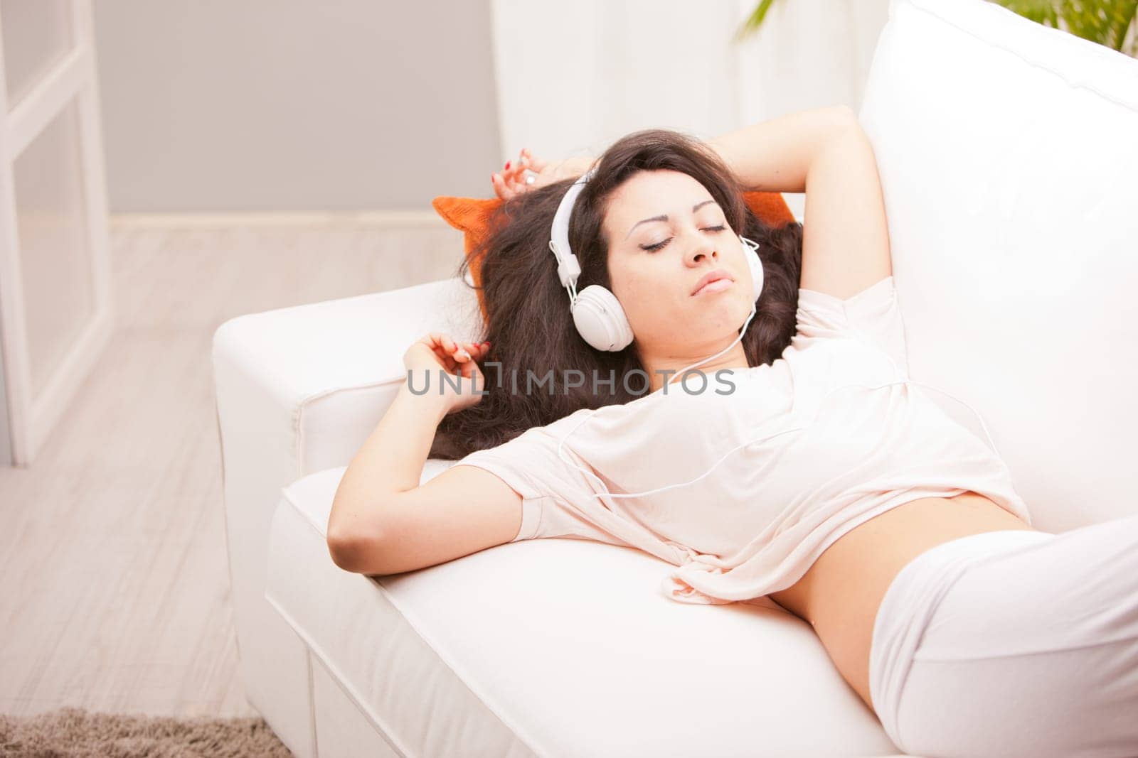 girl listening to music in her house dancing and singing happily in her living room