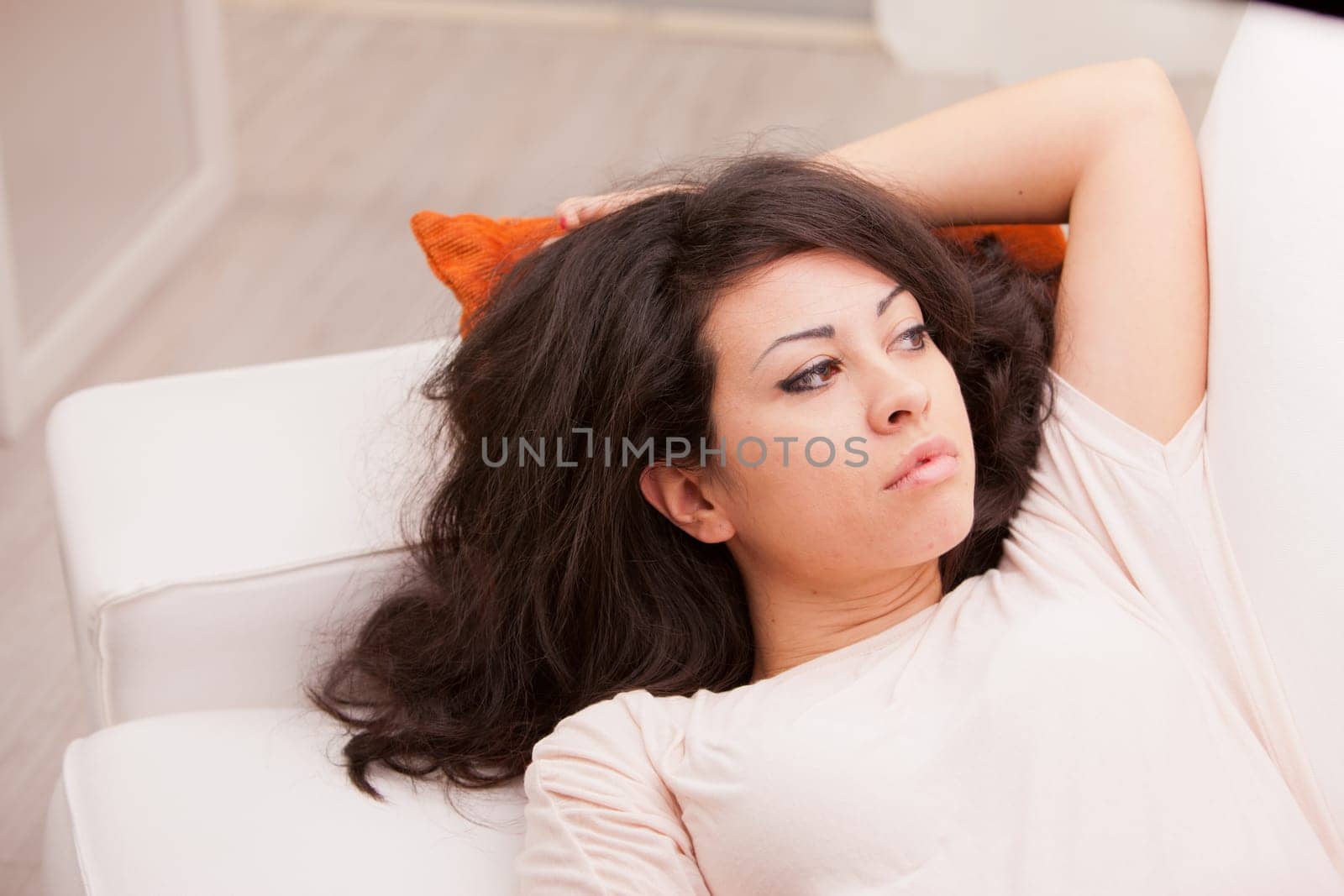 young wonderful woman relaxing on the sofa in her living room and thinking about her problems or the future or her love to come