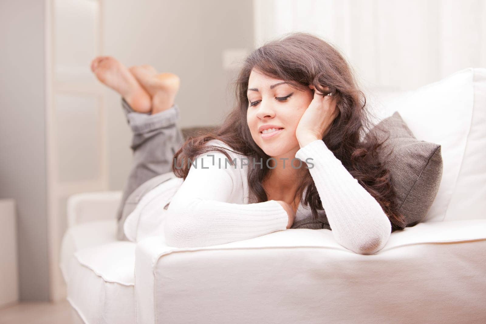 young wonderful woman relaxing on the sofa in her living room and thinking about her problems or the future or her love to come