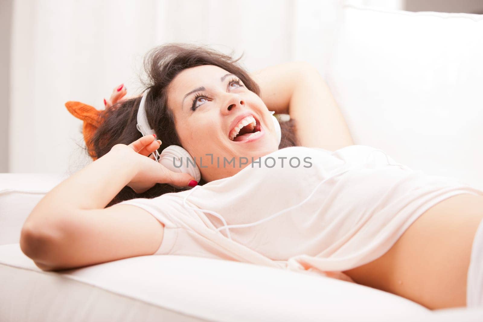 girl listening to music in her house dancing and singing happily in her living room