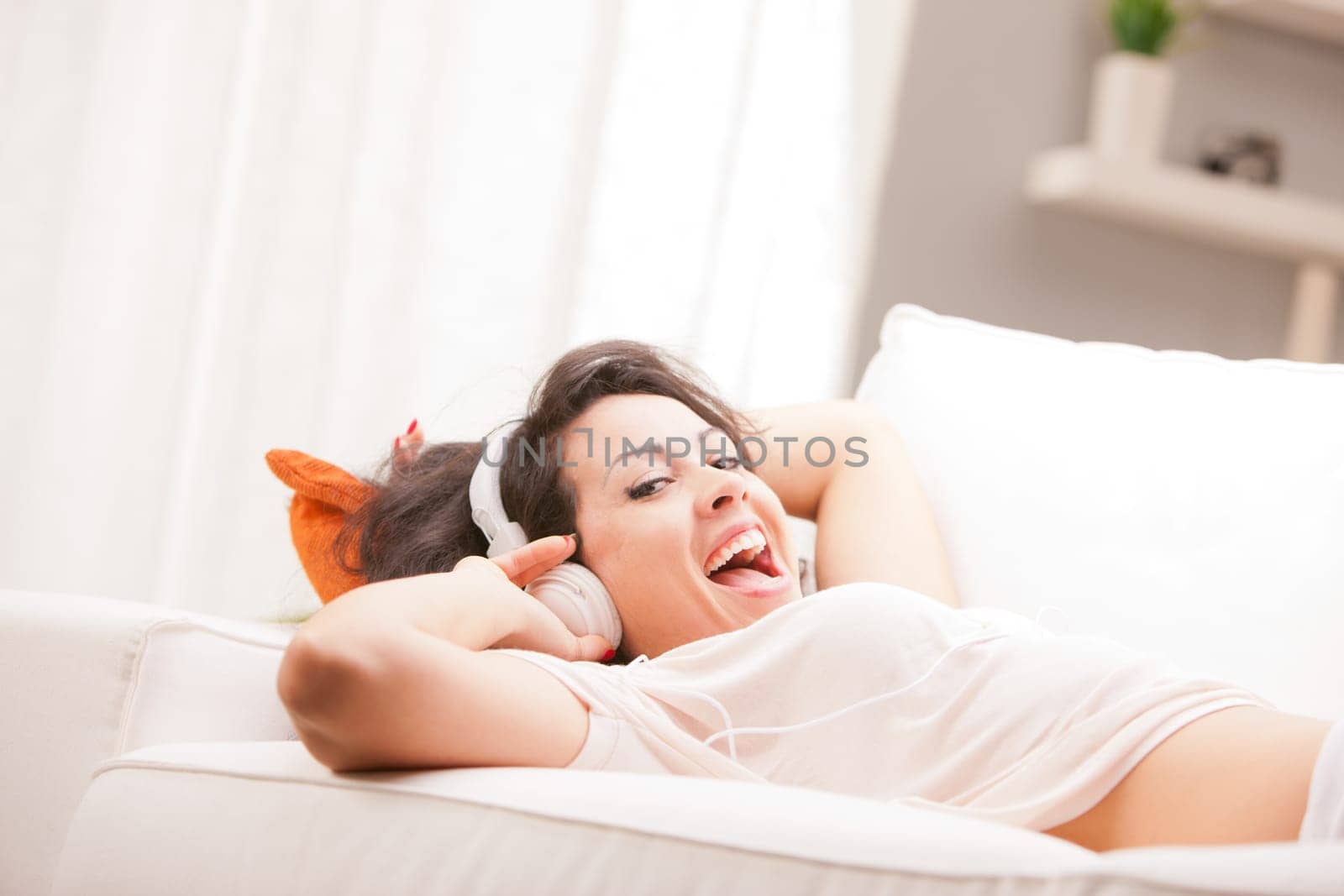 girl listening to music in her house dancing and singing happily in her living room