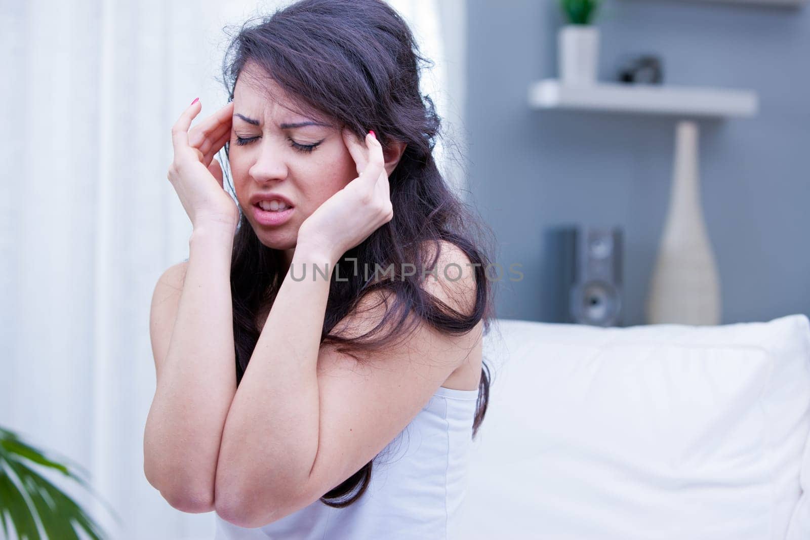 beautiful girl has a painful headache in her living room and wants immediately a painkiller