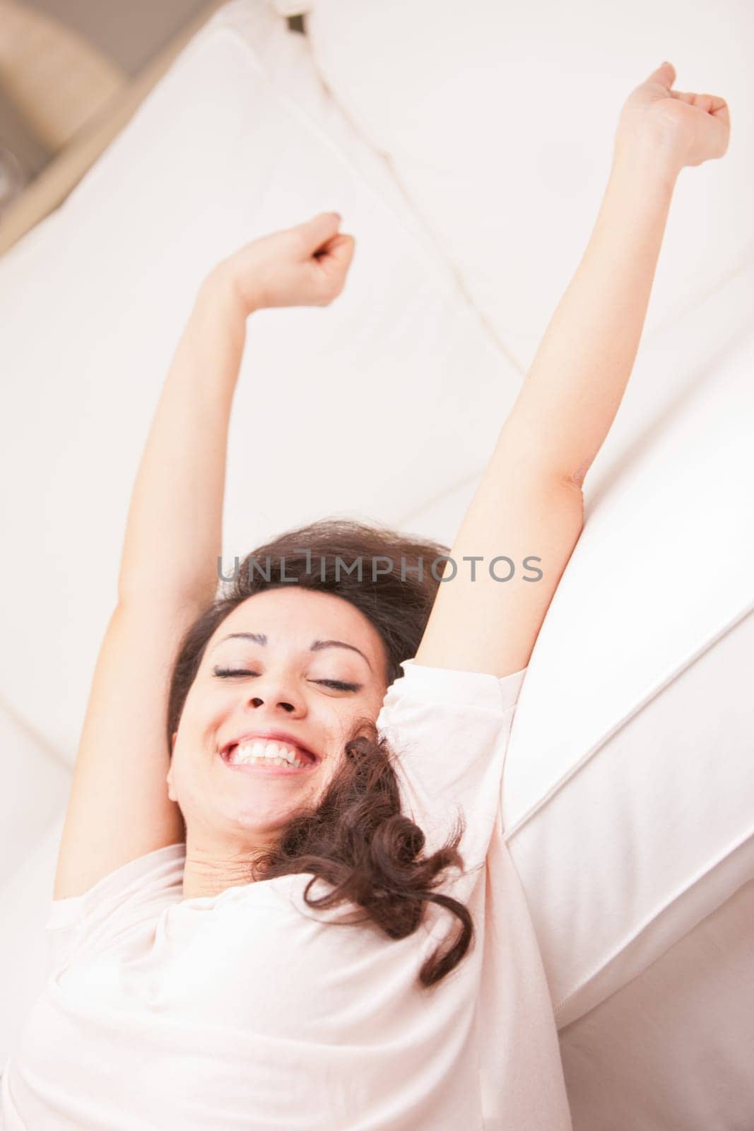 this girl is girl stretching and yawning in the morning in her living room