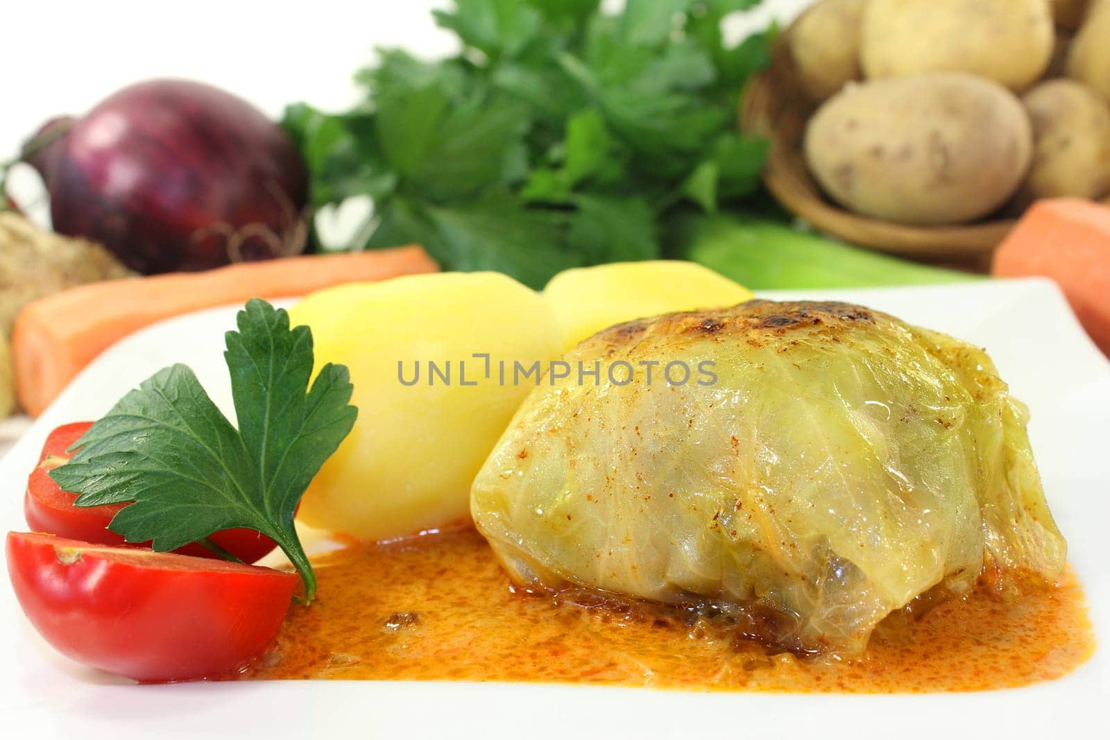 a plate of cabbage roulade and potatoes