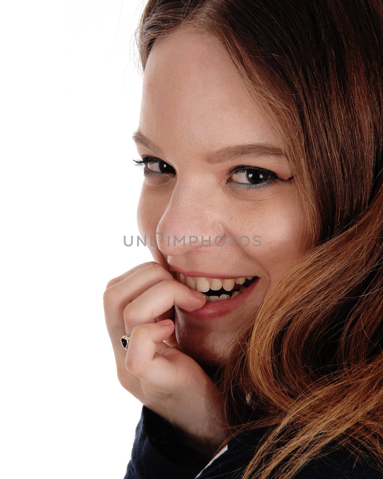 A beautiful smiling face of a young woman in close up with one hand on.her face, with long brunette hair, isolated for white background.
