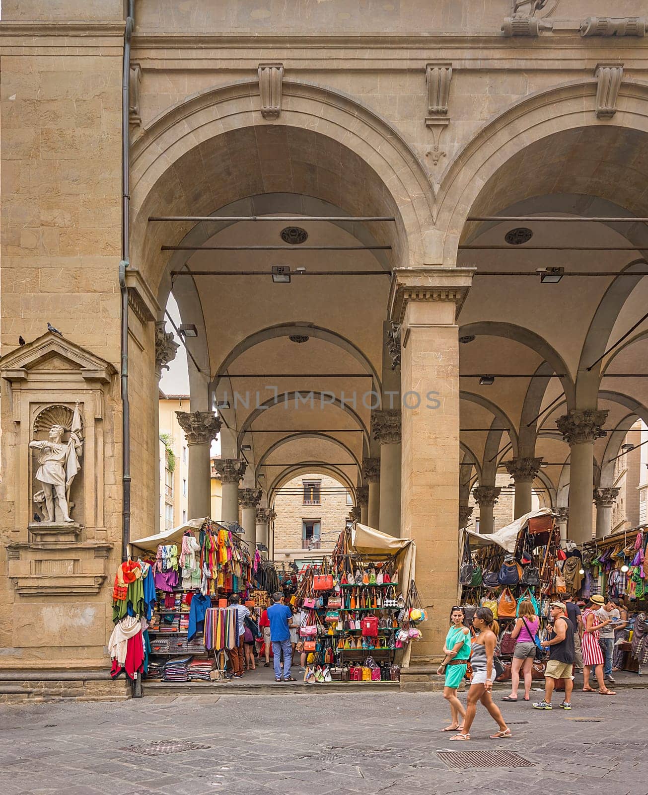 Florence, Italy, June 2015: tourists and Florentines walking and shopping in the historic Mercato del Porcellino (pig market) in the center of Florence with Tuscan leather goods