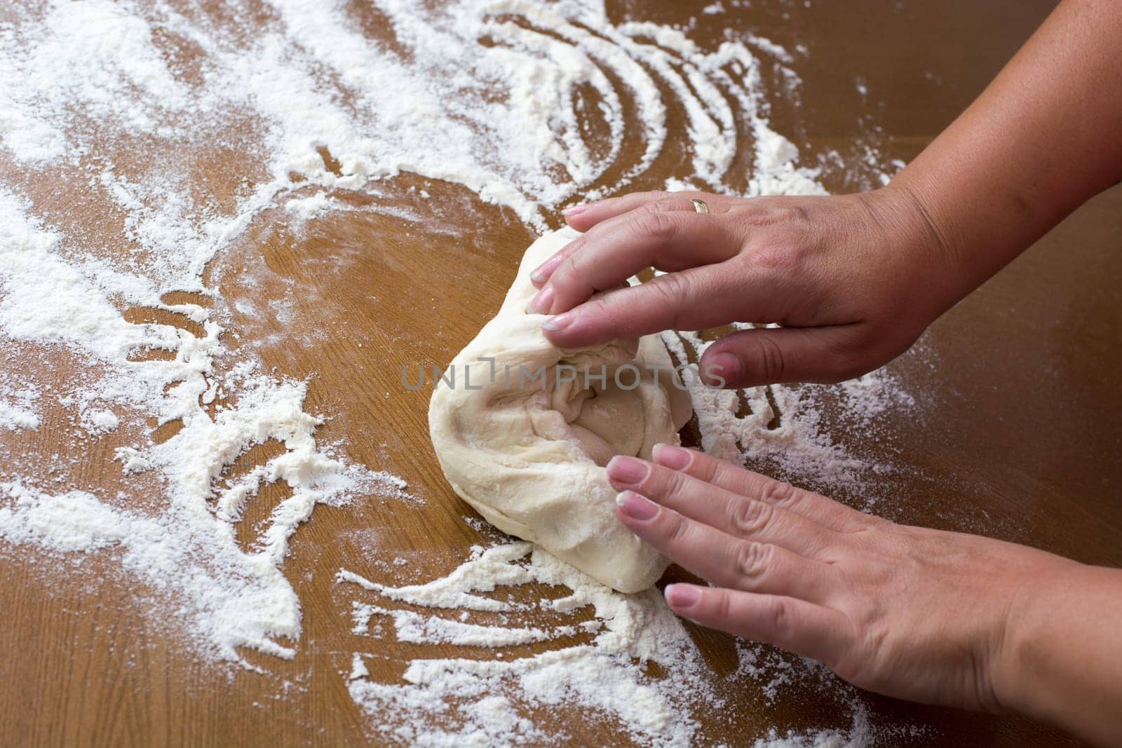 Woman making dough with meat at home on the kitchen table