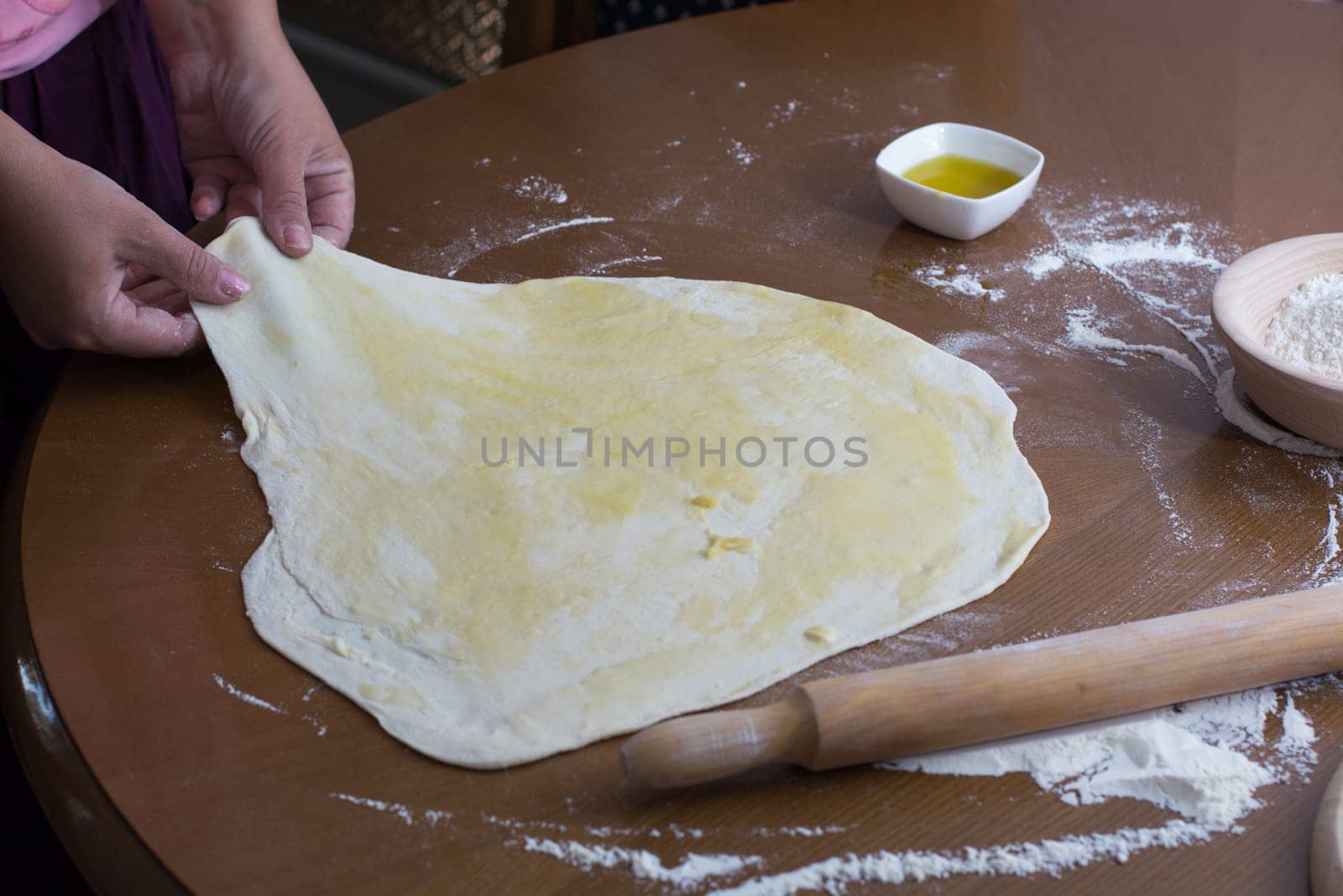 Woman making dough with meat at home on the kitchen table