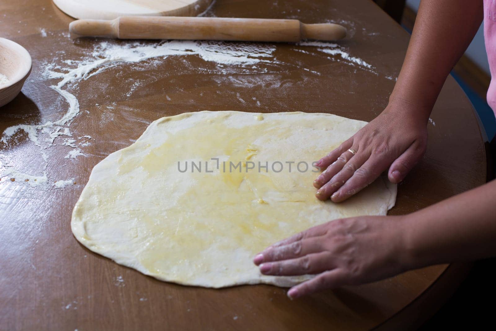 Woman making dough with meat at home on the kitchen table