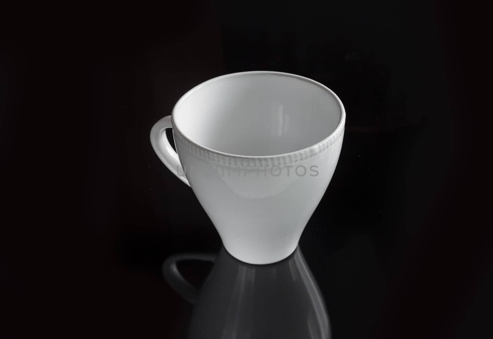 White empty cup on a dark background for a drink
