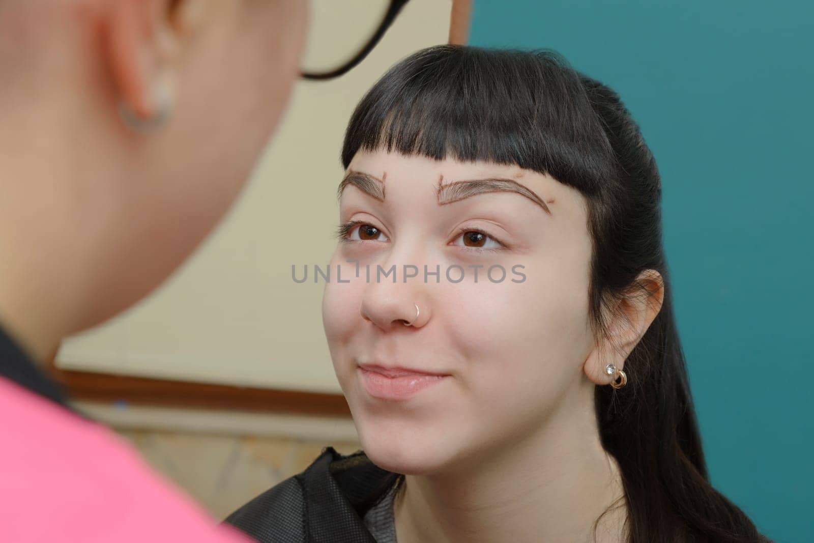 Permanent makeup. Verification of proportions. Cosmetologist applying permanent make up on eyebrows- eyebrow tattoo