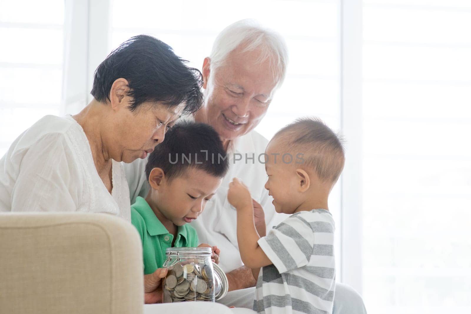 Asian old people and children saving money at home. Family financial planning, investment, insurance, retirement, senior and junior banking concept.