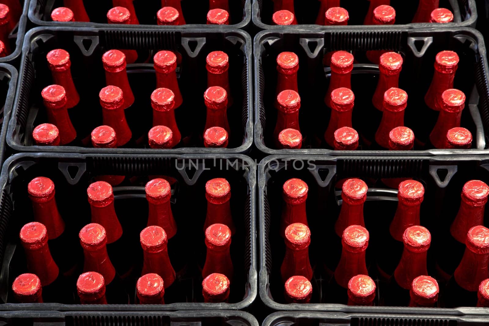A group of red bottles in beer crates