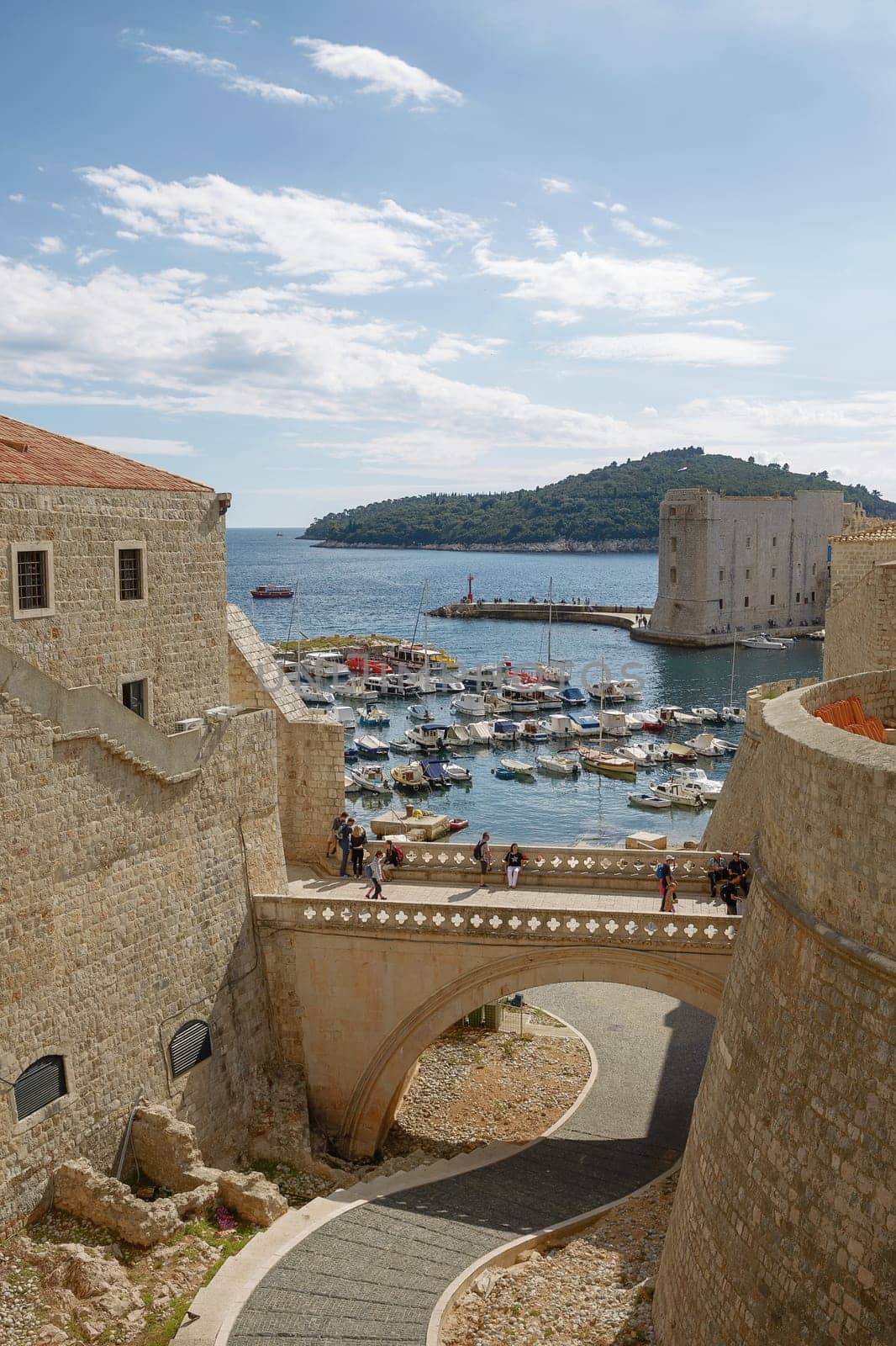 DUBROVNIK, CROATIA - OCTOBER 10, 2017: Port and tourists viewed through fortress walls in Dubrovnik, Croatia