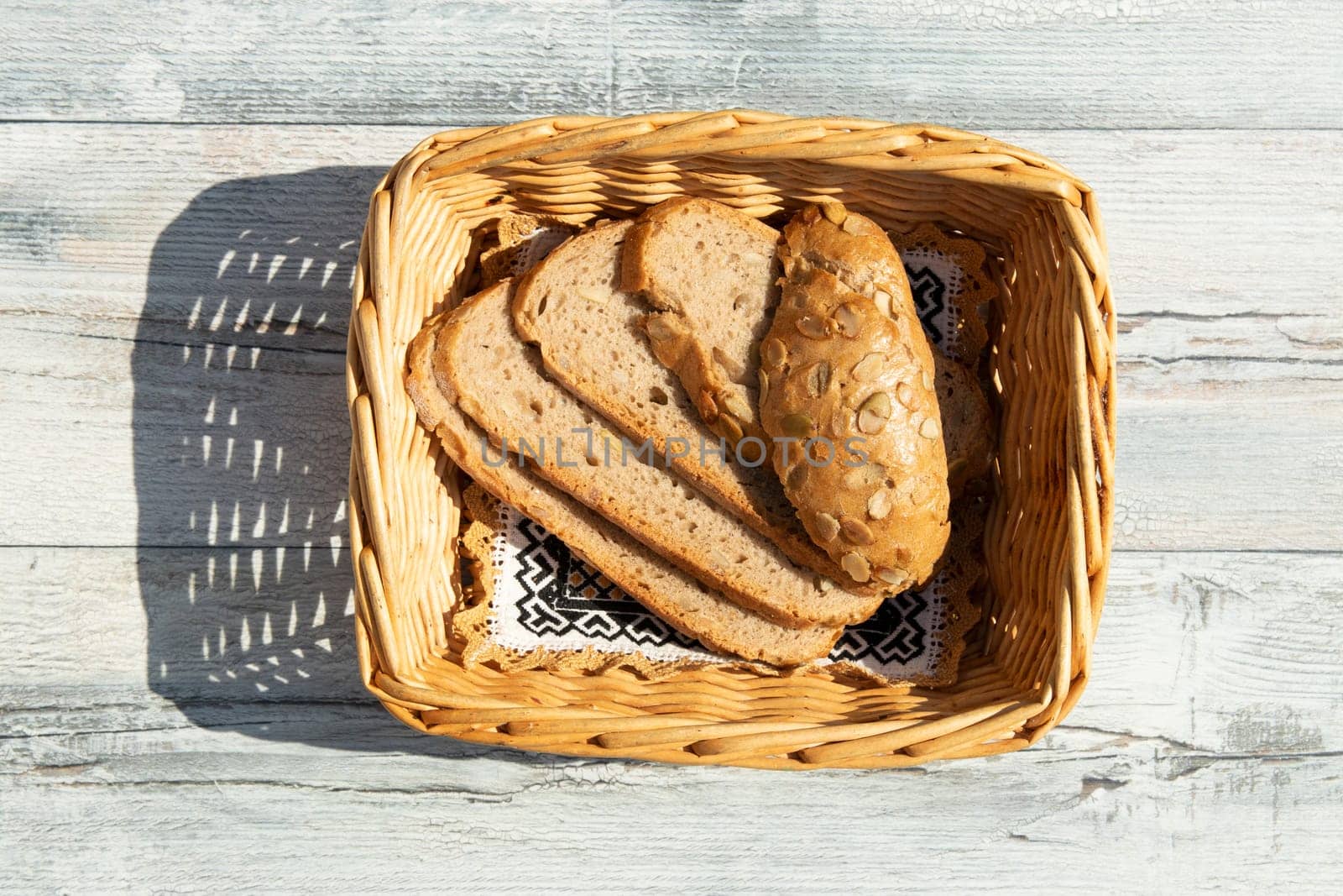 Whole grain bread in basket presented on wooden tabel.  Health concept. top view