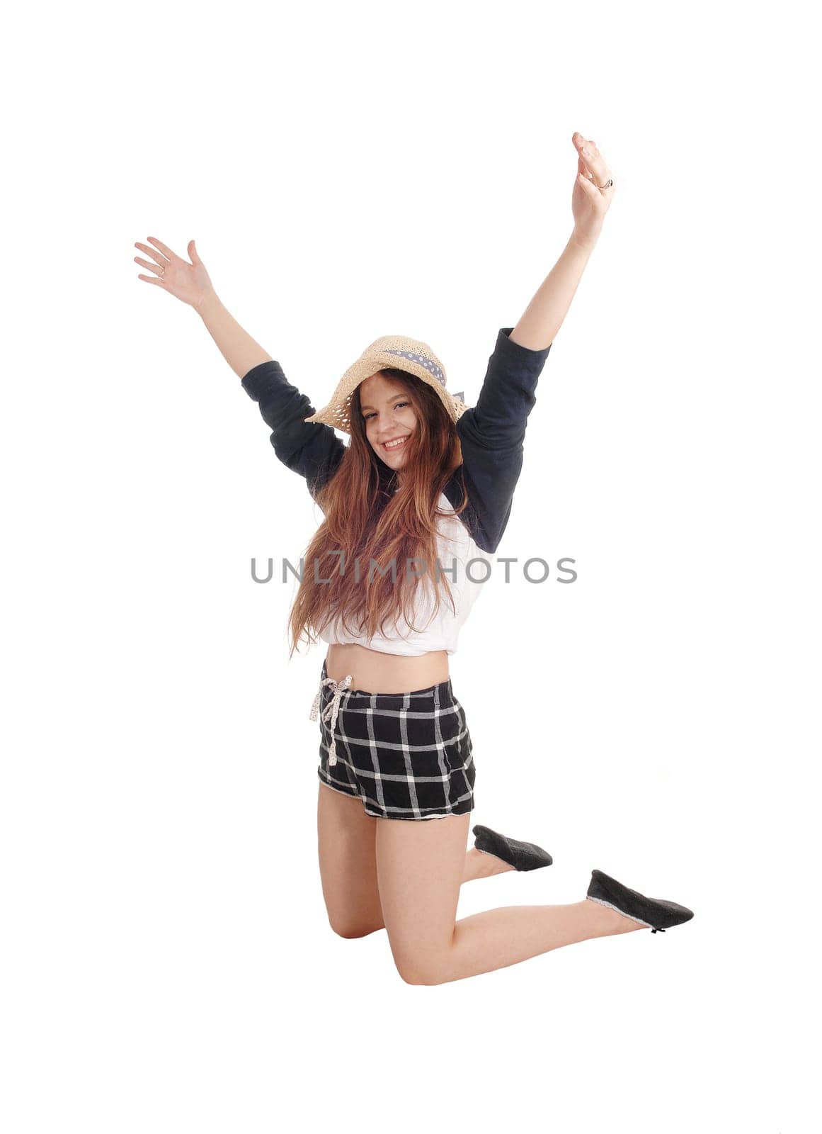 A happy young slim woman jumping from the floor wearing shorts and.a straw hat, isolated for white background.