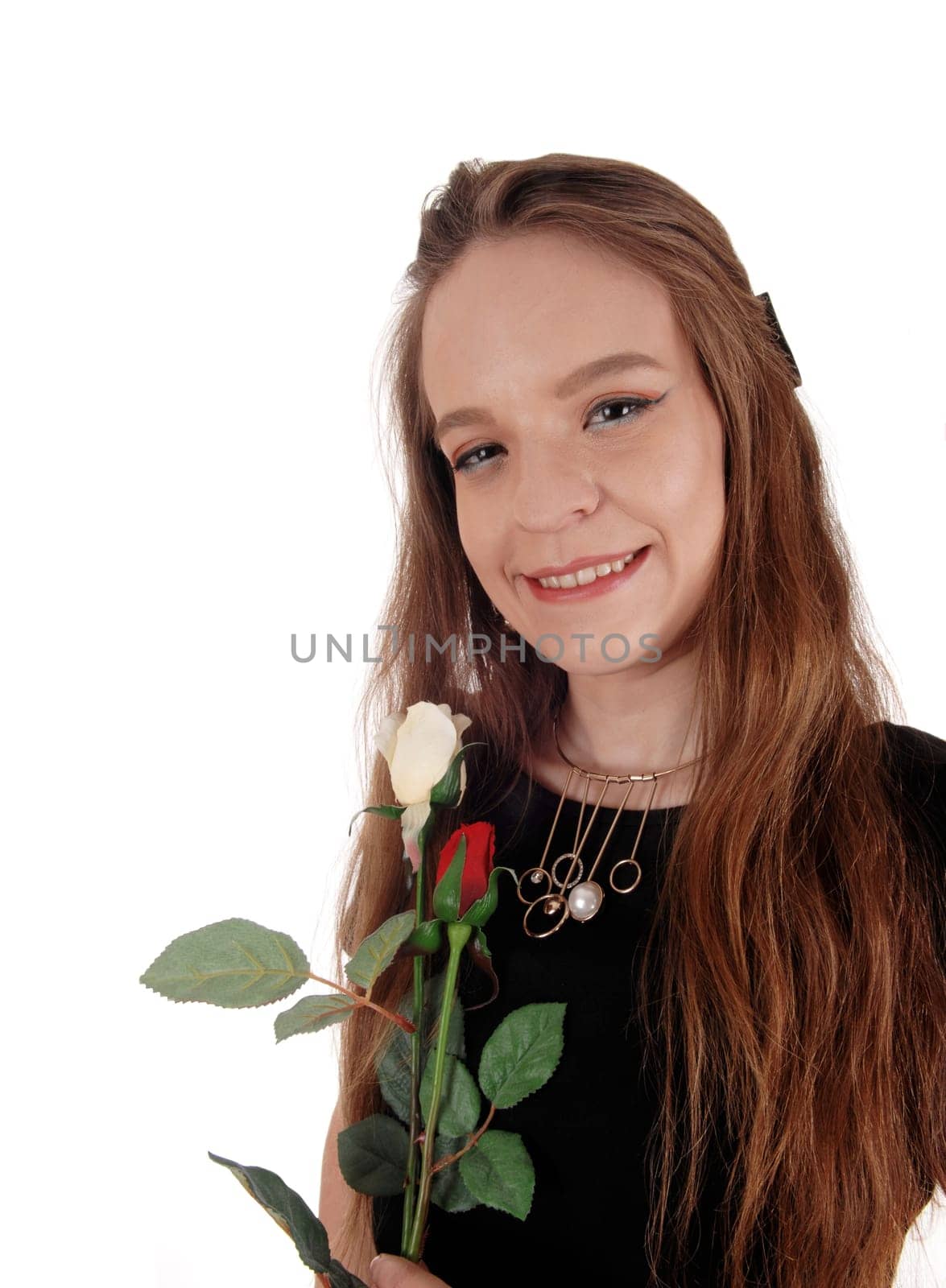 A lovely young woman in a portrait image and long brunette hair and.black dress, holding a red rose, isolated for white background.