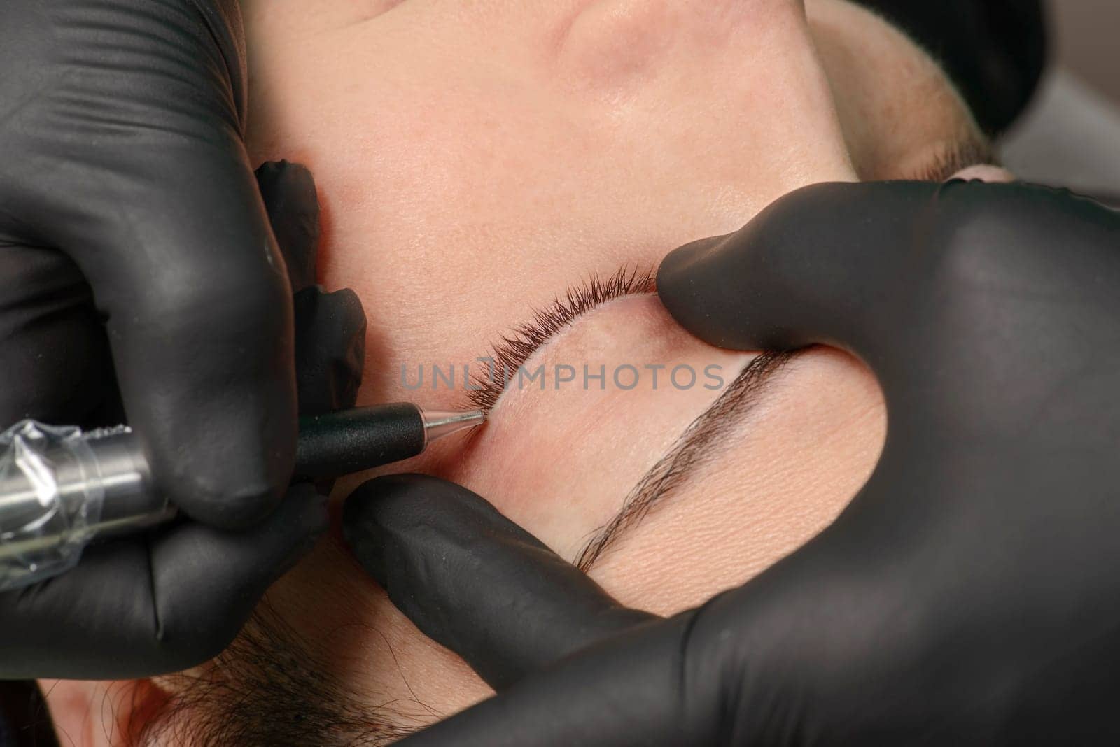 Permanent makeup. Permanent tattooing of eyebrows. Cosmetologist applying permanent make up on eyebrows- eyebrow tattoo