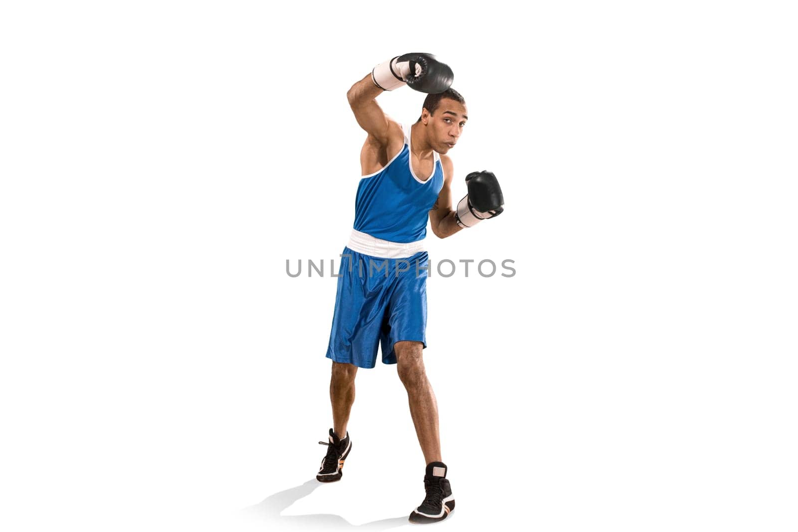 Sporty man during boxing exercises. Photo of boxer on isolated on white background. Strength, attack and motion concept. Fit african american model in movement. Afro muscular athlete in sport uniform