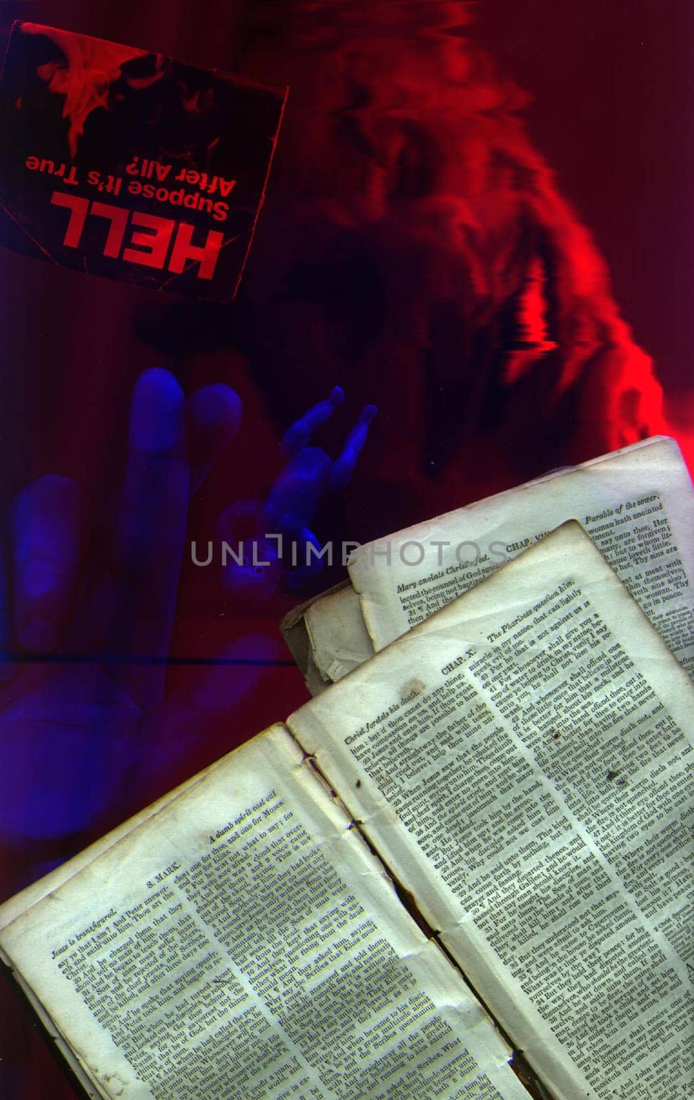 Pages from Bible. Demon face, doll and human hand.