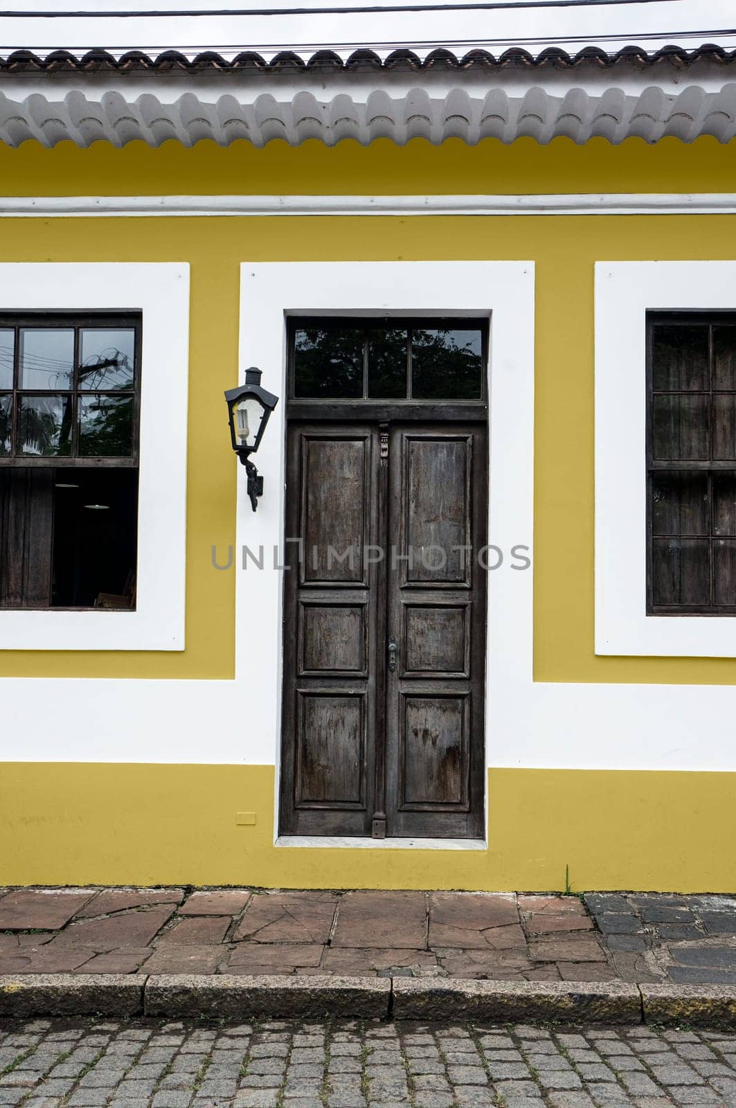 city Morretes Brazil old light chandelier design wooden door glass windows yellow wall