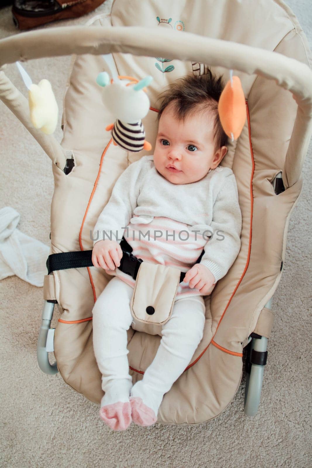 Portrait of a baby girl in her bouncer chair at home.